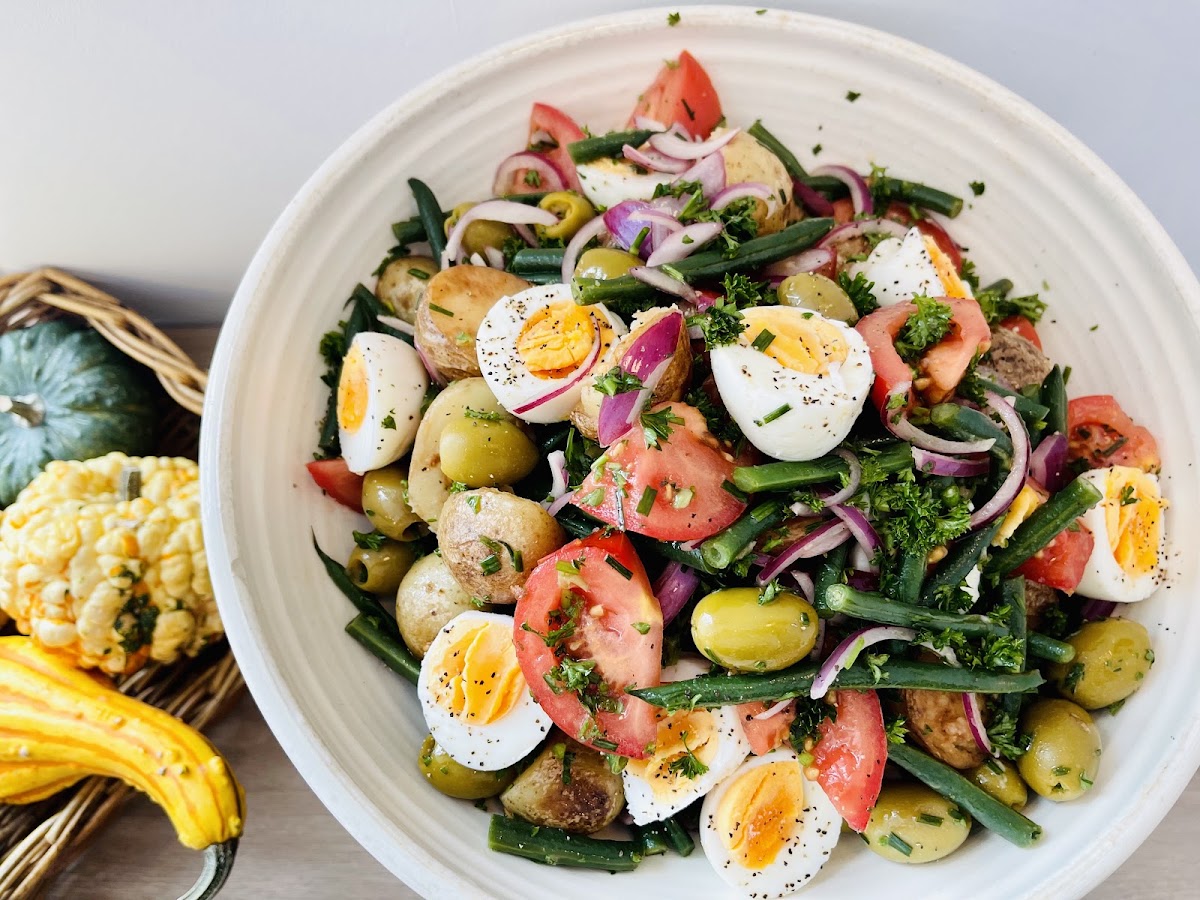 Fresh salad bowl with eggs, olives, beans and tomato