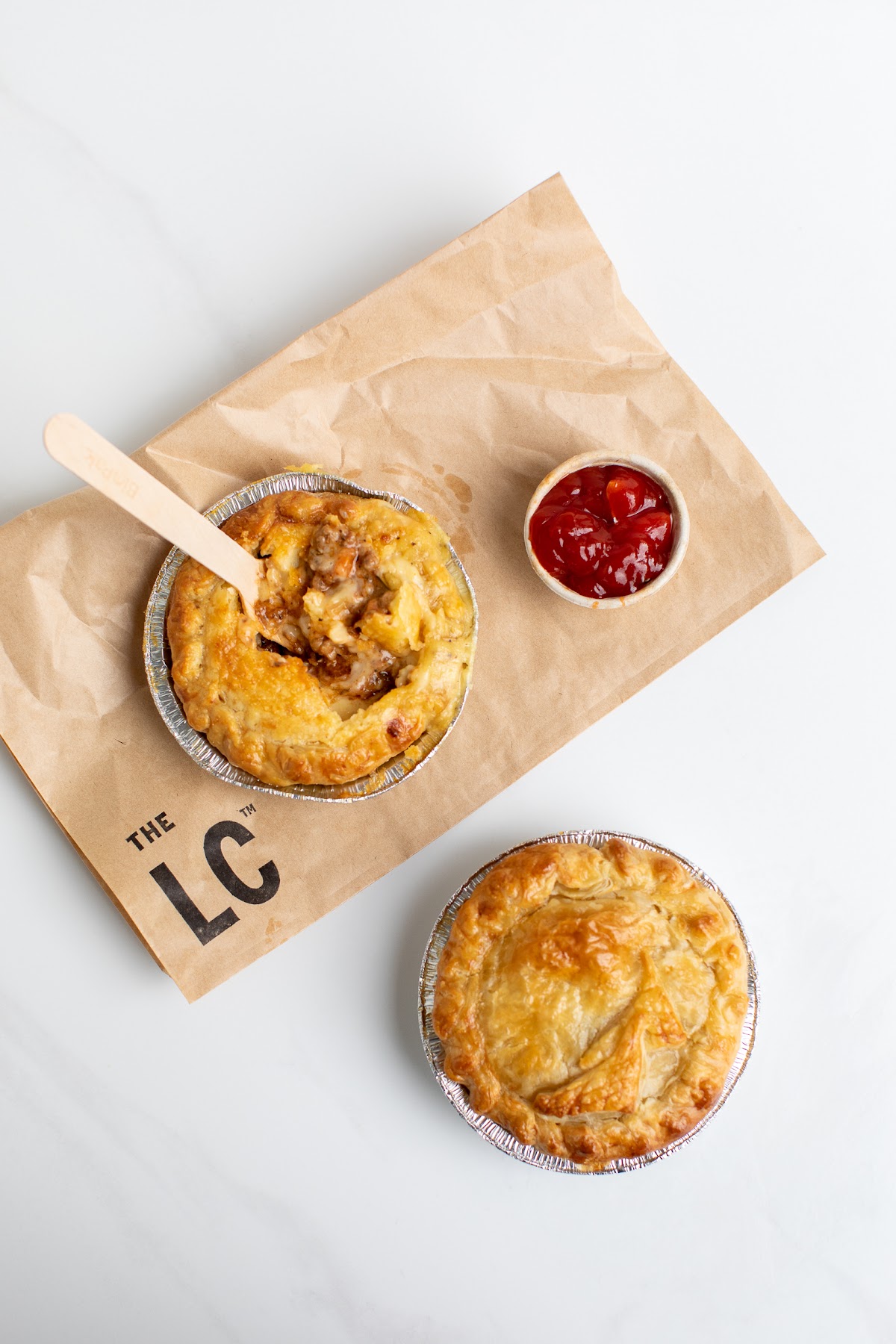Two house-made pies with tomato sauce on branded LC paper