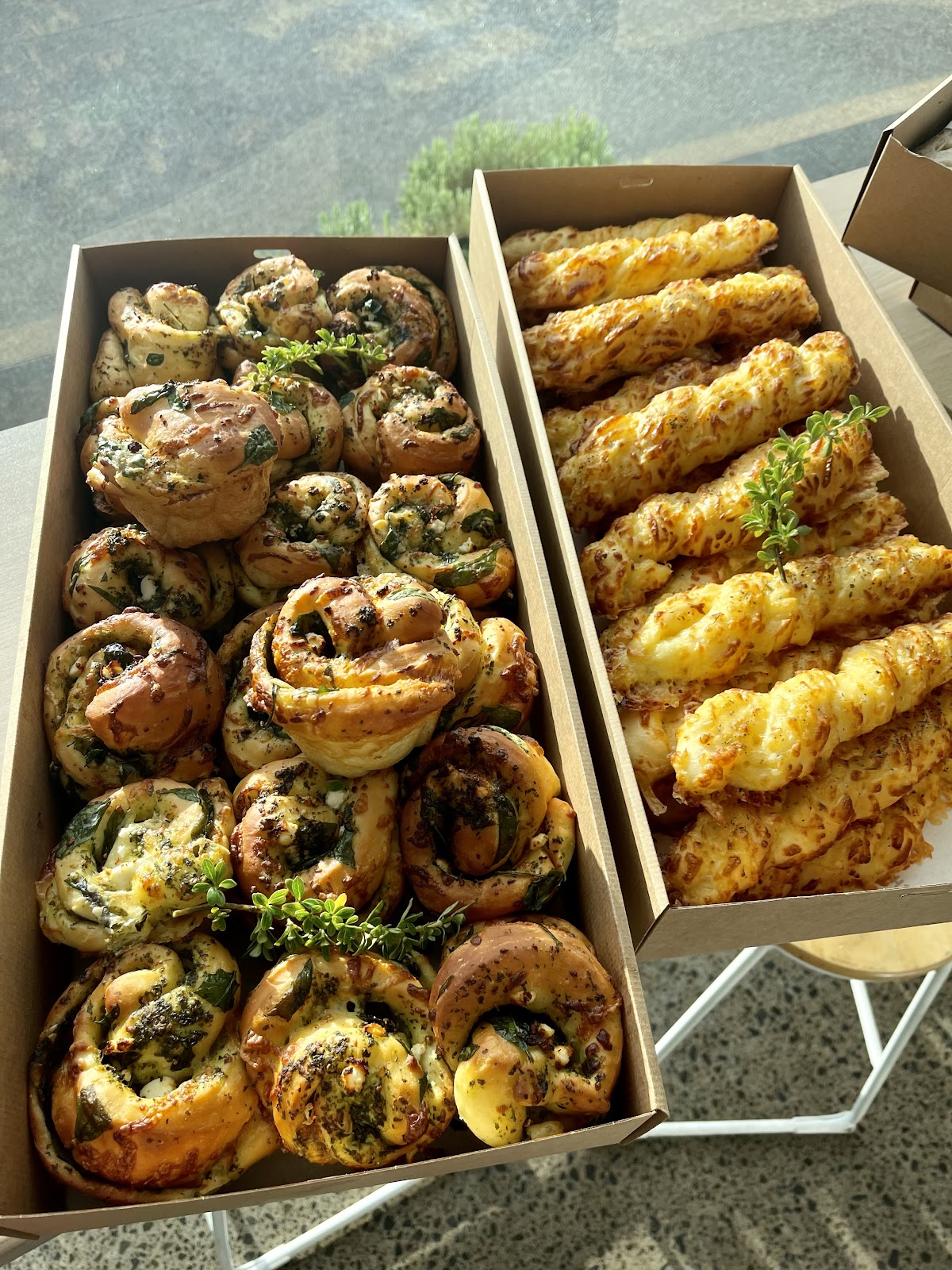 Catering boxes of pesto scrolls and cheese twists