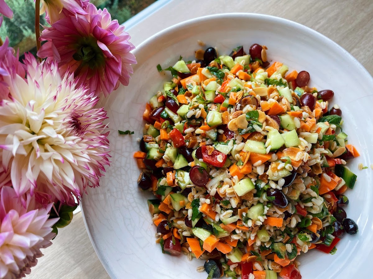 Colourful grain salad with dahlias on the table