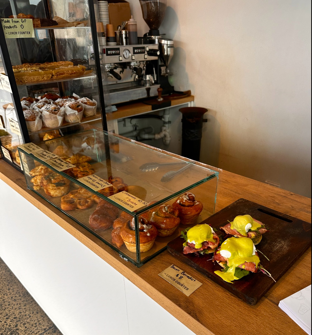 The cabinet: muffins, cinnamon brioche, donuts and Bacon Benedict by the coffee machine