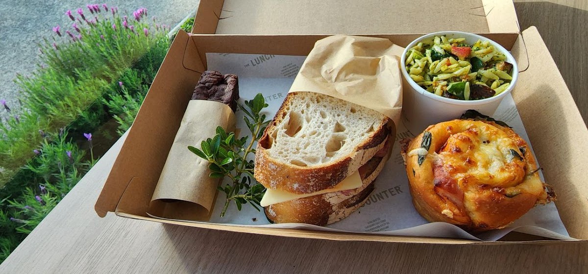 Individual catering lunchbox with sandwich, salad, scroll and brownie